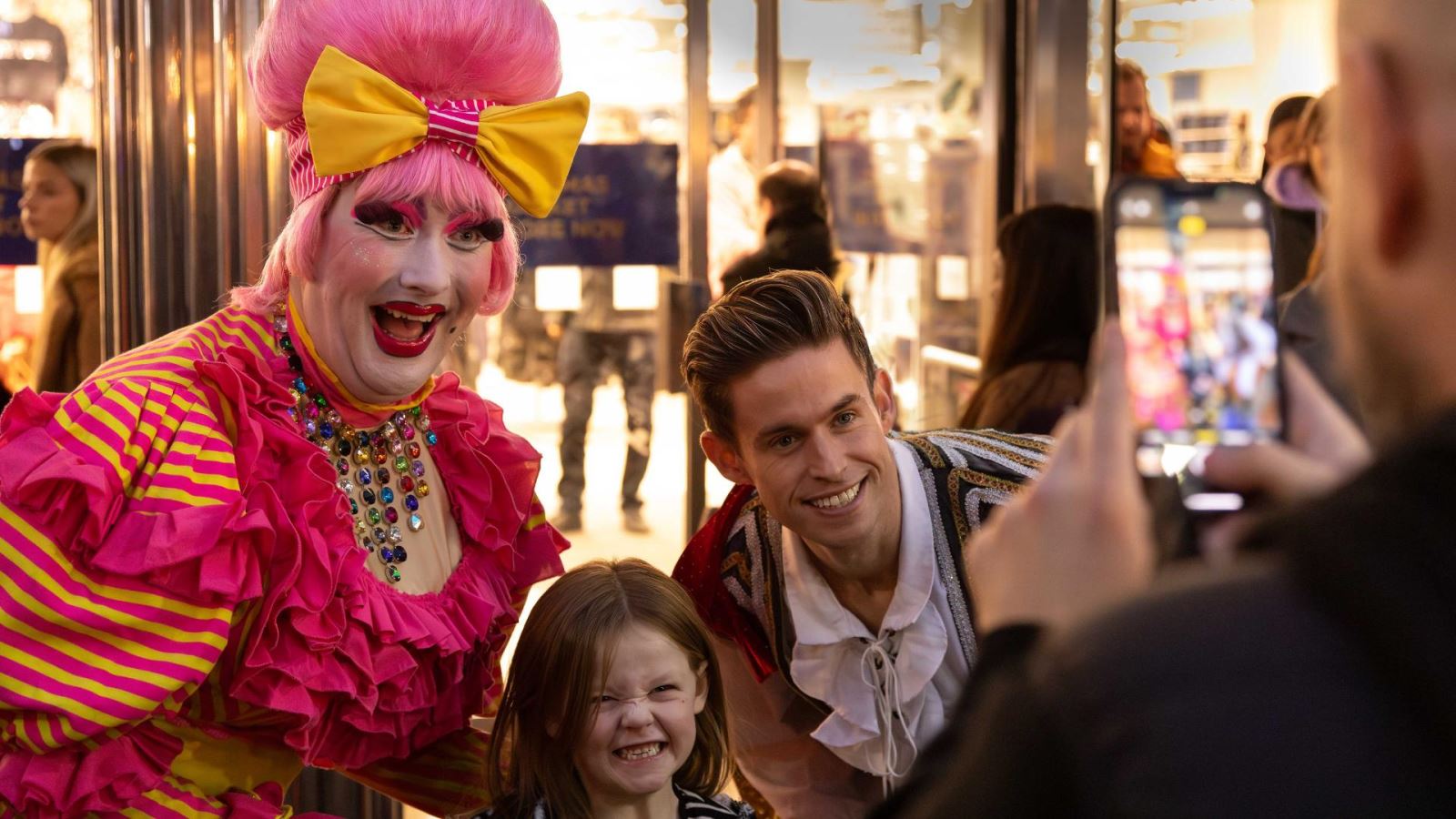 Child posing for photo with panto actors